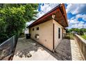 Side view of the home featuring a wooden deck, concrete walkway and storage shed at 6310 Lake Underhill Rd, Orlando, FL 32807