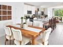 Open dining area with a wooden table, six upholstered chairs, and a view of the modern kitchen at 647 Pennywort St, Lake Alfred, FL 33850