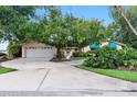 Charming home with a well-maintained lawn, mature trees, and a spacious driveway leading to a two-car garage at 65 Oakdale St, Windermere, FL 34786