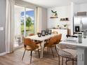Bright dining area with sliding glass doors to patio, modern light fixture and wood-look flooring at 651 Pennywort St, Lake Alfred, FL 33850