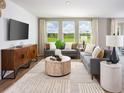 Inviting living room with large windows offering scenic views, stylish furniture, and a modern rug at 651 Pennywort St, Lake Alfred, FL 33850