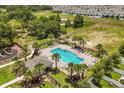 Aerial view of a sparkling community pool surrounded by lush landscaping and lounging areas at 827 Grandin St, Davenport, FL 33837