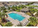 Aerial view of a sparkling community pool surrounded by lush landscaping and lounging areas at 827 Grandin St, Davenport, FL 33837