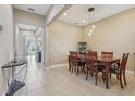 Formal dining room featuring tile floors, a wooden table set, and views into the living area at 9207 Busaco Park Way, Winter Garden, FL 34787