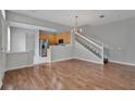Inviting living space with hardwood floors, staircase access, and a view of the kitchen at 976 Rock Harbor Ave, Orlando, FL 32828