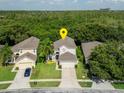 Aerial view of a charming two-story home with lush green lawn and landscaped garden at 9966 Hidden Dunes Ln, Orlando, FL 32832