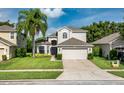 Charming two-story home with lush green lawn, landscaped garden, and attached two-car garage at 9966 Hidden Dunes Ln, Orlando, FL 32832