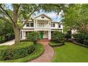 Elegant two-story home with lush landscaping, a brick walkway, and a covered porch, showcasing curb appeal at 1011 Lake Davis Dr, Orlando, FL 32806