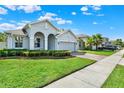 Inviting home exterior with fresh green grass, well-kept landscaping, and a brick paver driveway at 1061 Castlevecchio Loop, Orlando, FL 32825