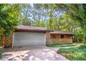 Spacious home featuring an attached two-car garage with a brick facade and well-kept landscaping at 109 Poinciana Ln, Deltona, FL 32738