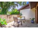 Relaxing patio area with outdoor seating, surrounded by lush greenery and a charming brick wall at 109 Poinciana Ln, Deltona, FL 32738
