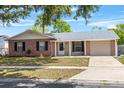 Well-maintained single-story home features brick accents, a manicured lawn, and an attached one car garage at 110 Rabun Ct, Sanford, FL 32773