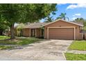 Single-story home with attached two-car garage, driveway, and mature shade tree at 119 Glendale Dr, Longwood, FL 32750