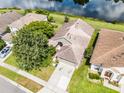 An aerial view of a home with a beautiful pond view and lush landscaping in a desirable neighborhood at 1252 Ballyshannon Pkwy, Orlando, FL 32828