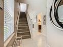 Bright hallway featuring tiled floors, stairs leading upstairs, and decor accents at 1521 Tranquil Ave, Clermont, FL 34714