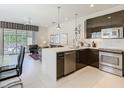 Modern kitchen with stainless steel appliances and an adjacent living area at 1521 Tranquil Ave, Clermont, FL 34714
