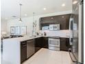Sleek kitchen featuring stainless steel appliances, white countertops and modern cabinetry at 1521 Tranquil Ave, Clermont, FL 34714