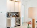 Modern bar area with white cabinets, stainless steel appliances, and a sleek design at 1545 Fairview Cir, Reunion, FL 34747
