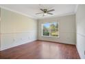 Bright bedroom with hardwood floors, crown molding, and a large window overlooking the yard at 2053 Dixie Belle Dr # 2053J, Orlando, FL 32812