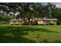 Charming single-story home boasts a lush front yard, mature trees, and a brick facade entry at 207 S Sweetwater Blvd, Longwood, FL 32779
