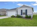 A single-story home with a well-manicured front lawn and a convenient two-car garage at 232 Summerlin Loop, Haines City, FL 33844