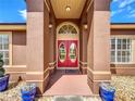 Inviting front entrance features double red doors, columns, and decorative landscaping at 2558 Ballard Ave, Orlando, FL 32833