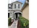 Inviting front entry with a brick pathway, covered porch, and lush greenery at 2564 River Landing Dr, Sanford, FL 32771