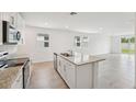 Well-lit kitchen with granite counters, stainless appliances, and island with sink and seating at 2778 Virginia Pine Dr, Bartow, FL 33830