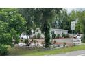 Home exterior with mature trees and a gravel drive at 31701 State Road 44 Sr-44, Eustis, FL 32736