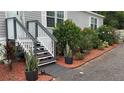 Exterior front stairs with beautiful landscaping, including potted plants and hibiscus bushes at 31701 State Road 44 Sr-44, Eustis, FL 32736