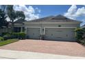 Charming single-story home with a two-car garage and a brick driveway at 31961 Redtail Reserve Blvd, Sorrento, FL 32776