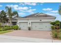 Attractive home featuring well-kept landscaping, a paver driveway, and a convenient two-car garage at 31961 Redtail Reserve Blvd, Sorrento, FL 32776