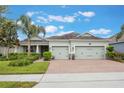 Inviting single-story home with lush landscaping, a two-car garage, and a welcoming brick driveway at 31961 Redtail Reserve Blvd, Sorrento, FL 32776