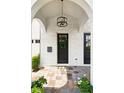 Charming front door with modern light fixture, brick archway, and neutral-toned tile walkway at 528 Greely St, Orlando, FL 32804