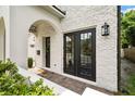 Close-up of a home's entry, showcasing double doors and intricate brick detailing around the arched entryway at 528 Greely St, Orlando, FL 32804