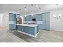 Stylish kitchen with blue cabinets, a center island, stainless steel appliances, and wood-look tile flooring at 530 Harriswood Ct, Davenport, FL 33837