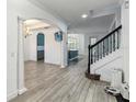 Inviting living space with wood-look tile flooring, archways, and staircase leading to the upper level at 530 Harriswood Ct, Davenport, FL 33837