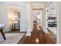 A spacious hallway featuring hardwood floors, decorative pillars, and neutral paint that creates an inviting and open transition at 5350 Penway Dr, Orlando, FL 32814