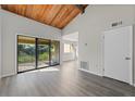 Open-concept living room with wood ceilings, lots of natural light, and access to a balcony at 6120 Peregrine Ave # A08-2, Orlando, FL 32819
