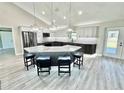 Spacious kitchen with gray cabinets, modern stainless appliances, and a large island with bar stool seating at 6449 Sw 180Th Cir, Dunnellon, FL 34432