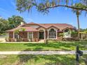 Charming single-story brick home with a well-kept lawn and mature trees at 700 Wyckliffe Pl, Winter Springs, FL 32708