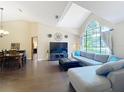 Open-concept living room with hardwood floors, a large window, and a comfortable sectional sofa at 700 Wyckliffe Pl, Winter Springs, FL 32708