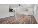 Bright living room showcasing wood floors, white trim, and an open floor plan to the kitchen at 709 Suzette Dr, Ocoee, FL 34761