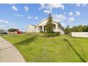 Attractive gray single-story house featuring a well-manicured lawn, shrubs, and a walkway at 730 Rominger Loop, Apopka, FL 32712