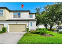 Charming two-story townhouse features a light beige garage and a bright green front lawn at 812 Benoi Dr, Davenport, FL 33896