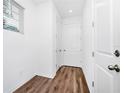 Hallway with wood-look flooring, white doors, and a window providing natural light at 812 Benoi Dr, Davenport, FL 33896