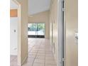 Neutral hallway with tile flooring leading to the living space and screened in patio at 10708 Brice Ct, Orlando, FL 32817