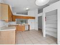 Spacious kitchen with tiled flooring, wood cabinets, and access to pantry and living area at 10708 Brice Ct, Orlando, FL 32817