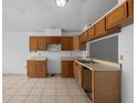 Kitchen featuring tiled floors, wood cabinets and a pass-through to living area at 10708 Brice Ct, Orlando, FL 32817