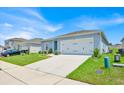 Well-maintained home with landscaped front yard and a two-car garage on a sunny day at 145 Piave St, Haines City, FL 33844